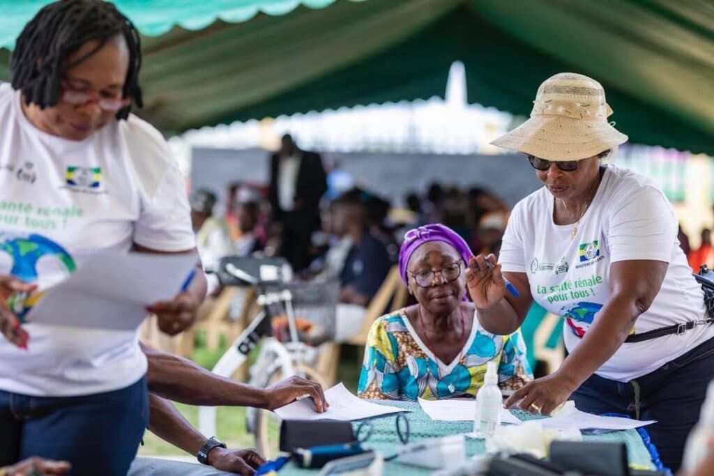 Deux bénévoles accueillent une visiteuse au stand de dépistage, Journée mondiale du rein 2026