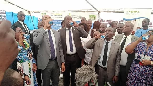 Officials drinking a glass of water under the World Kidney Day 2023 tents