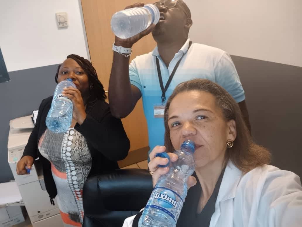 Trois membres de l’équipe boivent de l’eau pour le défi « Je m’arrête pour boire de l’eau »